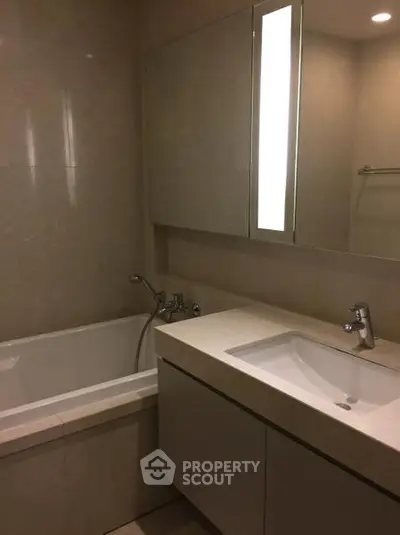 Modern bathroom with sleek fixtures and a bathtub in a contemporary apartment.