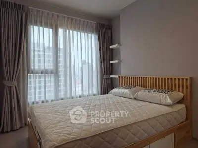 Spacious bedroom with large windows and modern decor in a high-rise apartment.