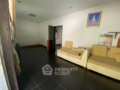Spacious living room with modern furniture and tiled flooring, perfect for relaxation.