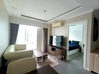 Modern living room with sleek furniture and natural light, adjacent to a cozy bedroom.