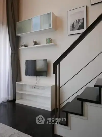 Modern living room with stylish staircase and wall-mounted TV