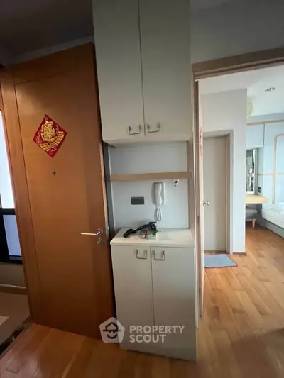 Cozy apartment interior with wooden flooring and built-in storage cabinets.