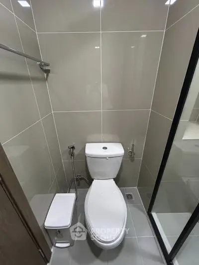 Modern bathroom with sleek design and high-quality fixtures, featuring a toilet and shower area.