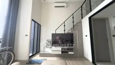 Modern living room with high ceiling and stylish staircase in a contemporary apartment.