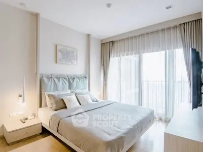 Elegant bedroom with large windows and modern decor in a bright apartment.