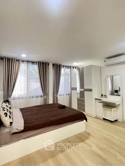 Spacious bedroom with modern decor and ample natural light