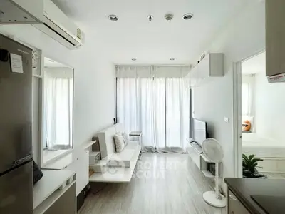 Bright modern living room with minimalist decor and large windows in a stylish apartment.