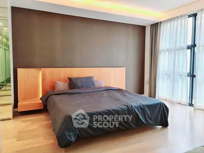 Spacious modern bedroom with large windows and elegant wooden flooring