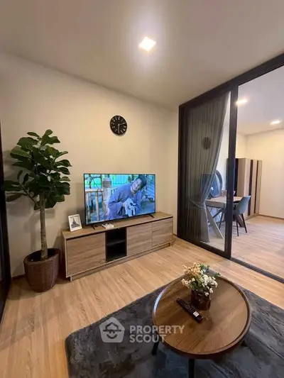Modern living room with sleek furniture and large sliding glass doors leading to a balcony.