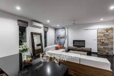 Modern living room with stylish decor and unique wall art, featuring a cozy seating area and sleek furniture.
