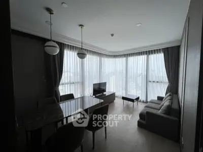Spacious living room with modern furniture and large windows offering a stunning city view.