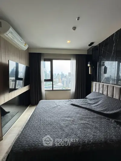 Luxurious bedroom with city view, modern decor, and wall-mounted TV in high-rise apartment.