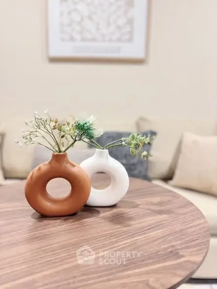 Stylish living room with modern decor and elegant vases on wooden table.