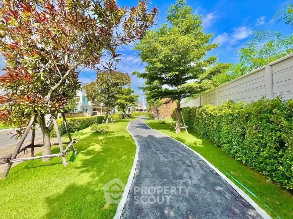 Beautiful garden pathway with lush greenery and vibrant trees in a residential area.
