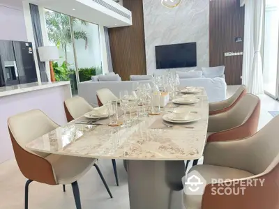 Luxurious modern dining area with elegant marble table and stylish chairs in open-plan living space.