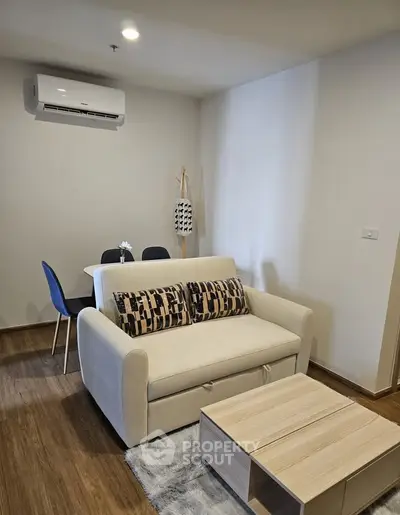 Modern living room with cozy sofa, dining area, and air conditioning in a stylish apartment.
