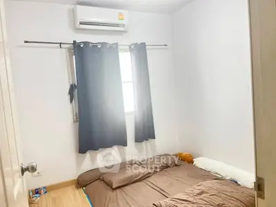 Cozy bedroom with air conditioning and natural light, featuring a comfortable bed and minimalist decor.