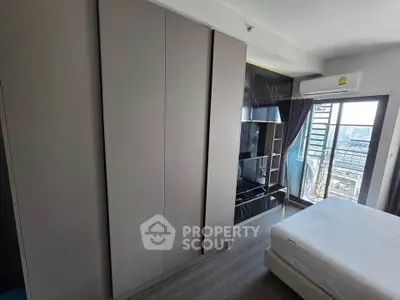 Modern bedroom with sleek wardrobe and city view balcony