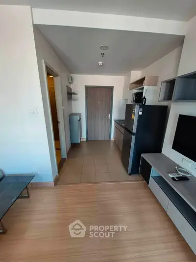 Modern apartment interior with open layout, featuring sleek kitchen and stylish living area.