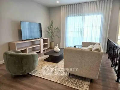 Stylish living room with modern furniture and large TV, perfect for relaxation.