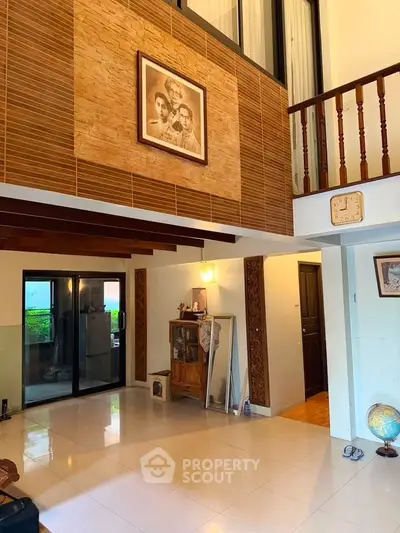 Spacious living room with high ceiling and elegant wooden accents