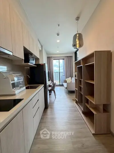 Modern open-layout kitchen leading to a cozy living room with city view.