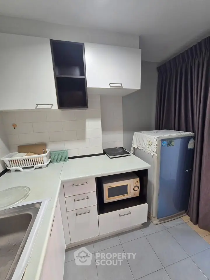 Compact kitchen with modern appliances and sleek cabinetry, perfect for urban living.
