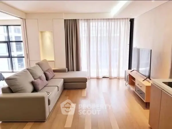 Modern living room with sleek furniture and large windows for natural light.