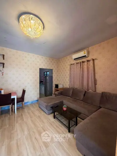 Spacious living room with elegant chandelier and cozy sectional sofa, perfect for relaxation and entertaining.