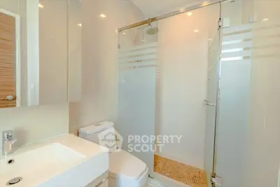 Modern bathroom with glass shower and sleek fixtures in a contemporary home.