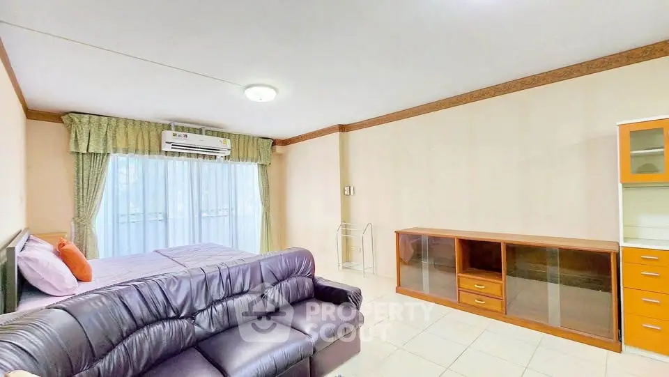 Spacious living room with modern furniture and large window for natural light.