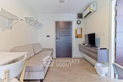 Modern living room with sleek furniture and wall-mounted TV in a cozy apartment.
