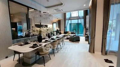 Luxurious open-plan living and dining area with elegant decor and large windows.