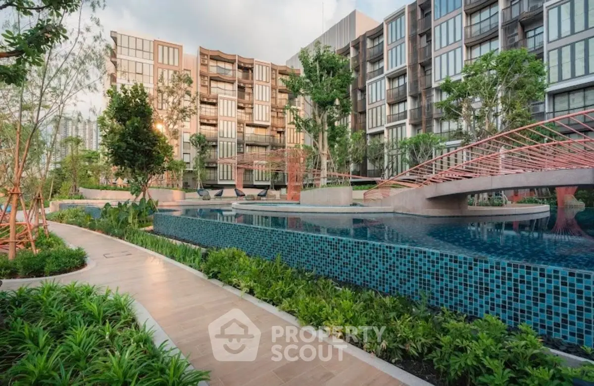 Luxurious residential complex with modern architecture and serene poolside view.