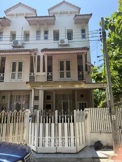 Charming three-story townhouse with gated entrance and classic architectural design.
