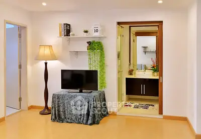 Modern living room with stylish decor and open view into a chic bathroom.