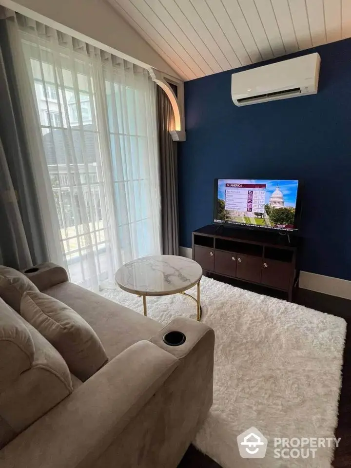 Cozy living room with plush sofa, stylish rug, and modern TV setup