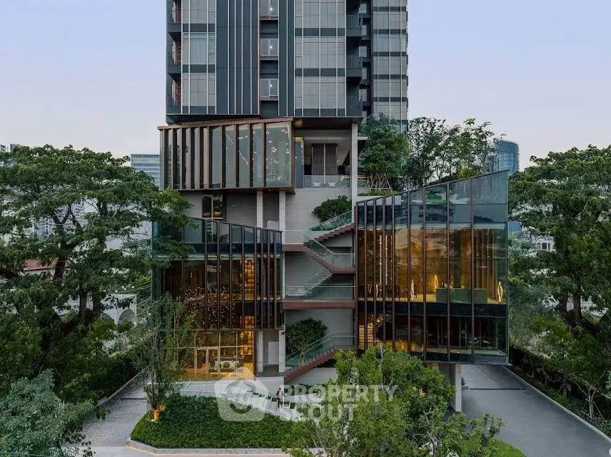 Stunning modern building exterior with lush greenery and glass facade, perfect for urban living.