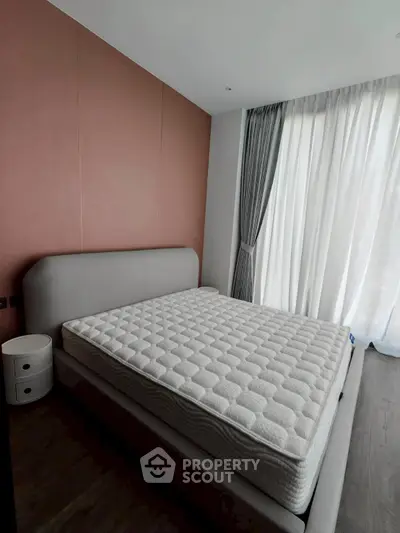 Modern bedroom with stylish bed and floor-to-ceiling windows in a contemporary apartment.