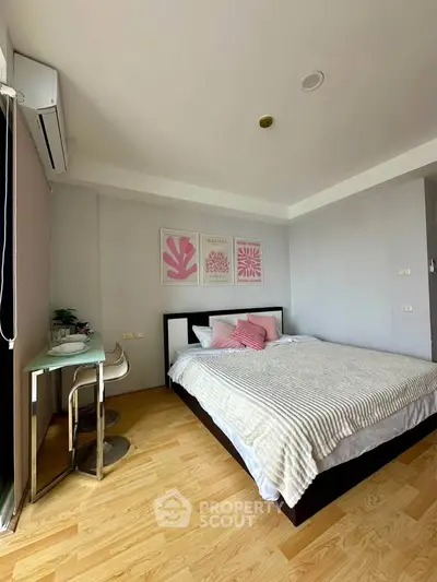 Cozy bedroom with modern decor and natural light, featuring a comfortable bed and stylish artwork.