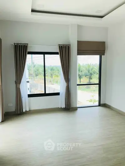 Bright and spacious room with large windows and scenic view, perfect for modern living.