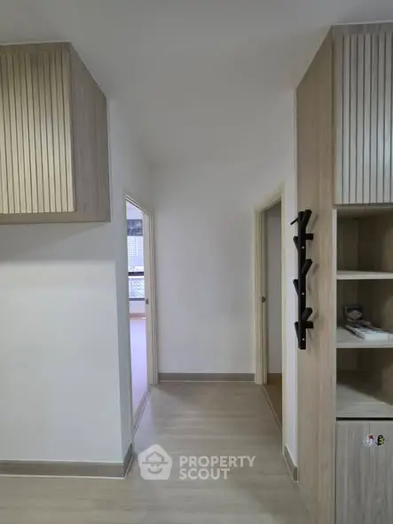 Modern hallway with wooden cabinetry and sleek design in a contemporary apartment.