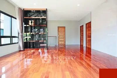 Spacious modern living room with polished wooden floors and large windows.