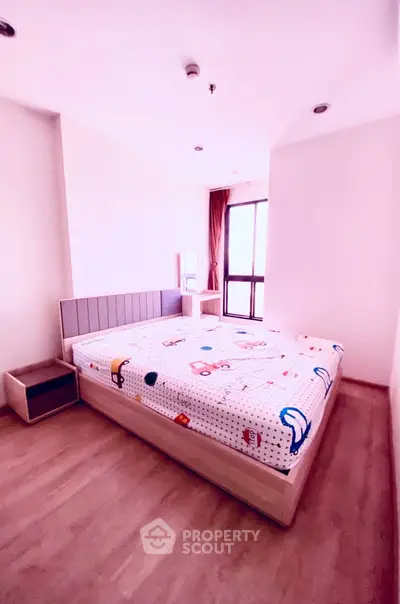 Spacious bedroom with modern decor and large window for natural light.