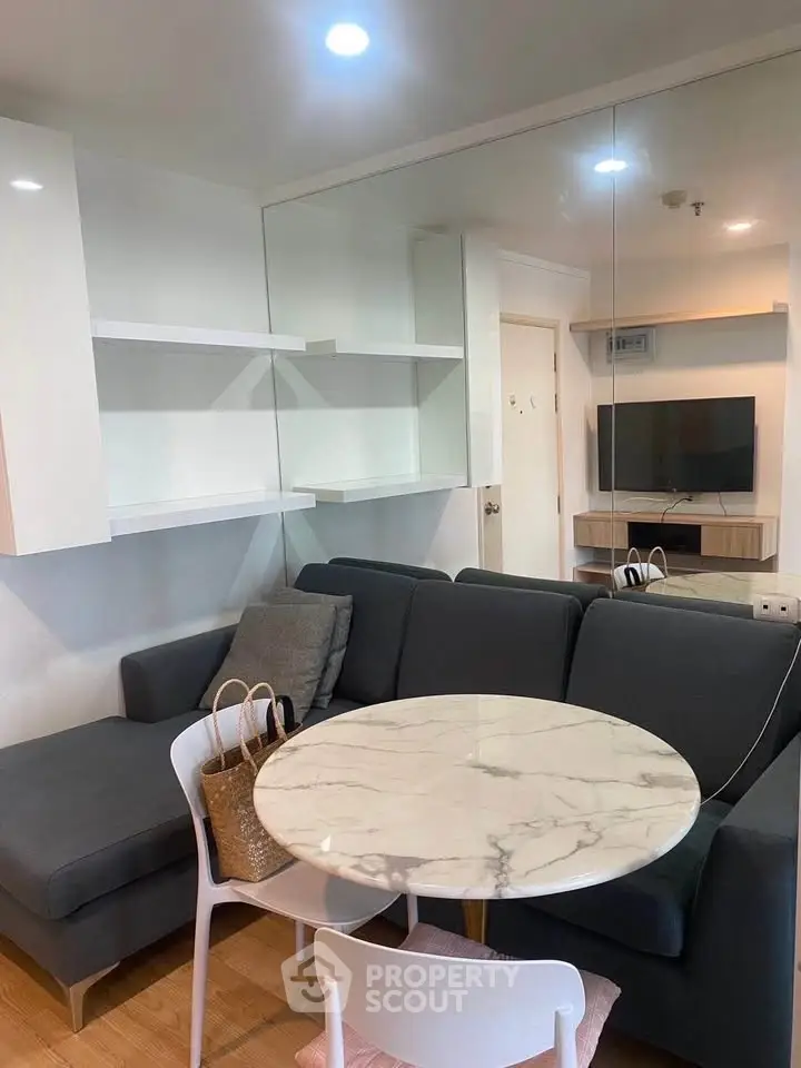 Modern living room with sleek furniture and marble table in a cozy apartment setting.
