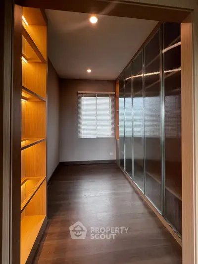 Spacious walk-in closet with elegant lighting and ample storage space.