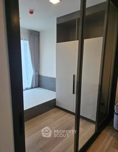 Modern bedroom with large wardrobe and natural light from window