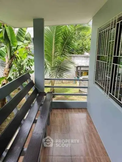 Charming balcony with garden view and cozy seating area, perfect for relaxation.