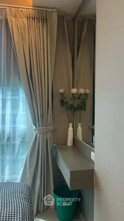 Cozy bedroom corner with elegant curtains and a stylish vanity mirror, perfect for modern living.