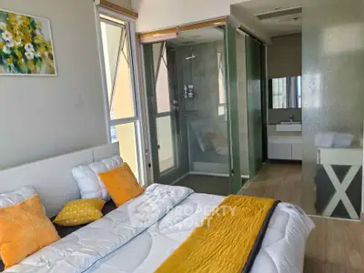 Modern bedroom with ensuite bathroom featuring glass shower and stylish decor.